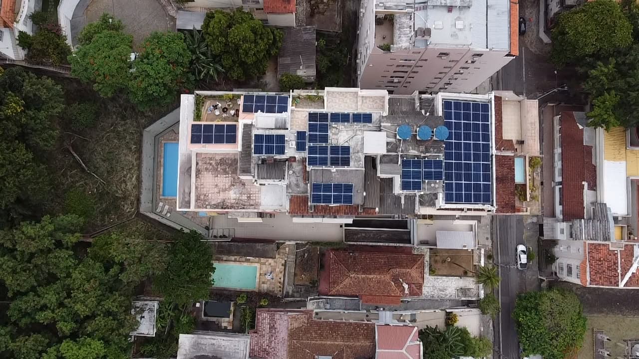Vista aérea de prédio urbano com piscina na cobertura e painéis solares instalados